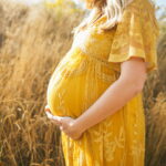 Schwangere Frau hält ihren Babybauch – Symphysenschmerzen in der Schwangerschaft